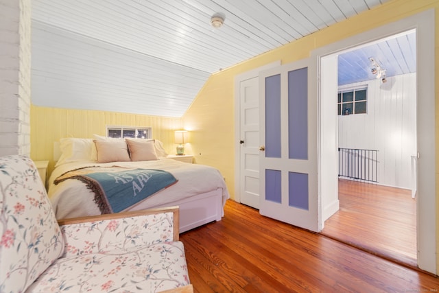 bedroom with wood walls, wood-type flooring, lofted ceiling, and wooden ceiling