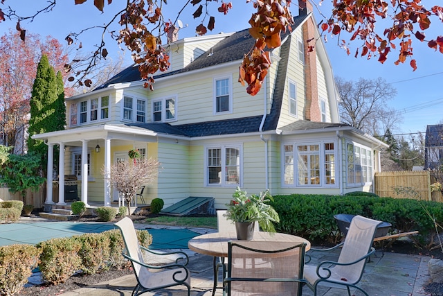 back of property with a patio area and a covered pool