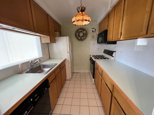 kitchen with decorative backsplash, sink, black appliances, pendant lighting, and light tile patterned flooring