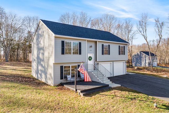 split foyer home featuring a front lawn and a garage