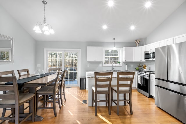 kitchen with pendant lighting, a center island, light hardwood / wood-style floors, and stainless steel appliances