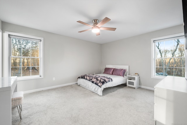 carpeted bedroom with multiple windows and ceiling fan