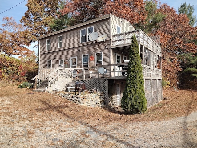 rear view of house featuring a garage and a wooden deck