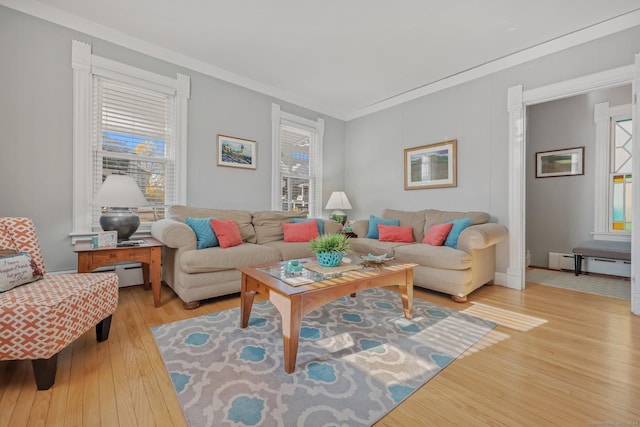 living room featuring baseboard heating, light wood-type flooring, and ornamental molding