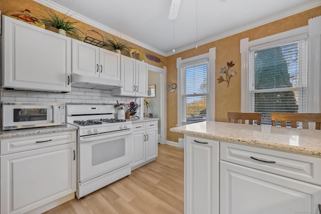 kitchen with white cabinetry, crown molding, and white gas range oven