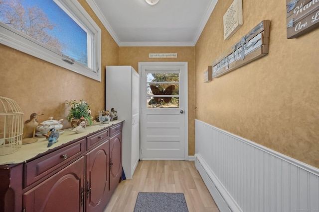 doorway featuring baseboard heating, crown molding, and light wood-type flooring