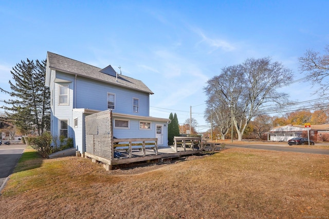 rear view of house featuring a yard and a deck