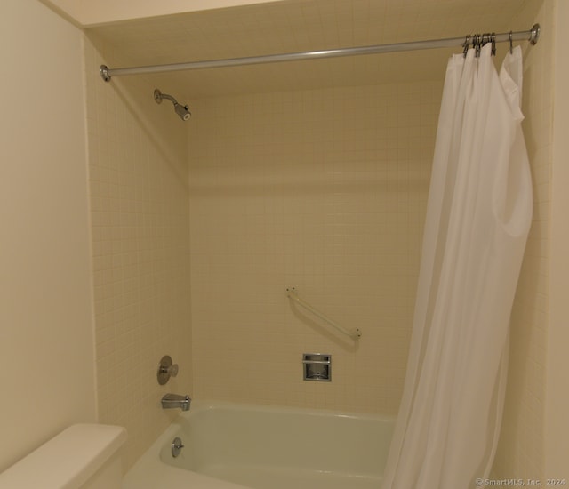 bathroom featuring shower / tub combo and toilet