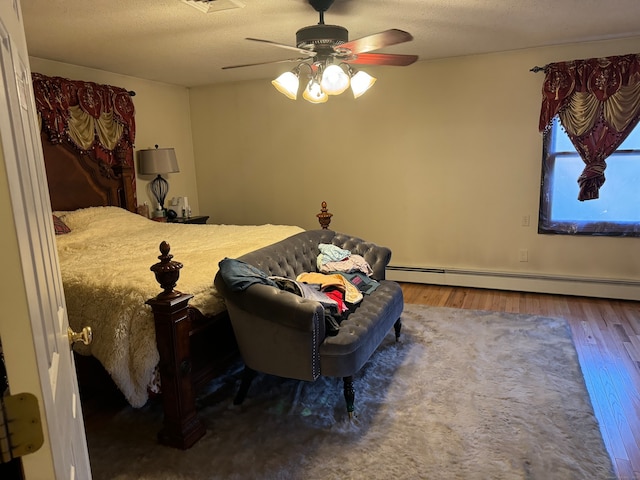 bedroom featuring hardwood / wood-style flooring, ceiling fan, a textured ceiling, and a baseboard radiator