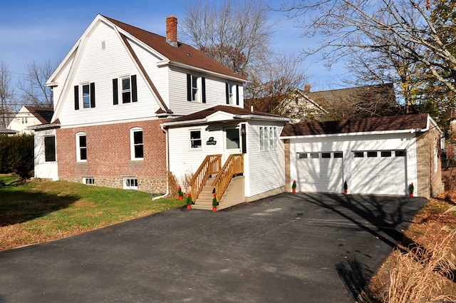 view of front of property with a garage, an outdoor structure, and a front lawn