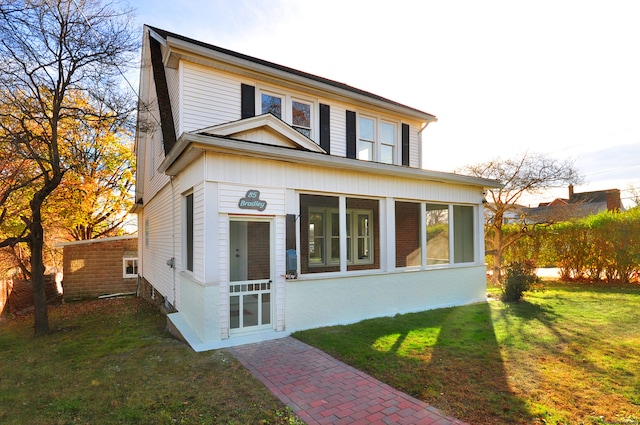 view of front facade featuring a sunroom and a front yard