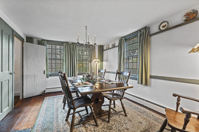 dining space featuring dark hardwood / wood-style flooring, a baseboard heating unit, and a notable chandelier