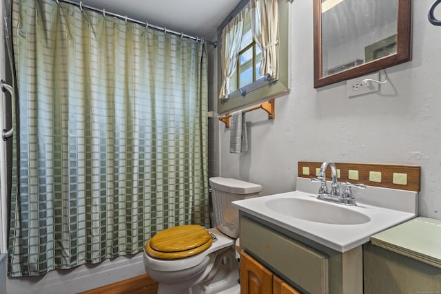 bathroom featuring a shower with shower curtain, vanity, and toilet