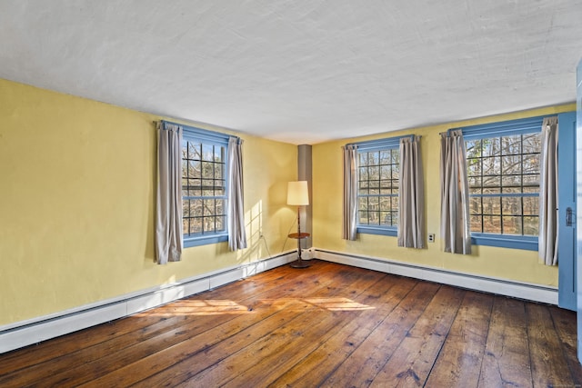 empty room with dark hardwood / wood-style floors, a healthy amount of sunlight, and baseboard heating