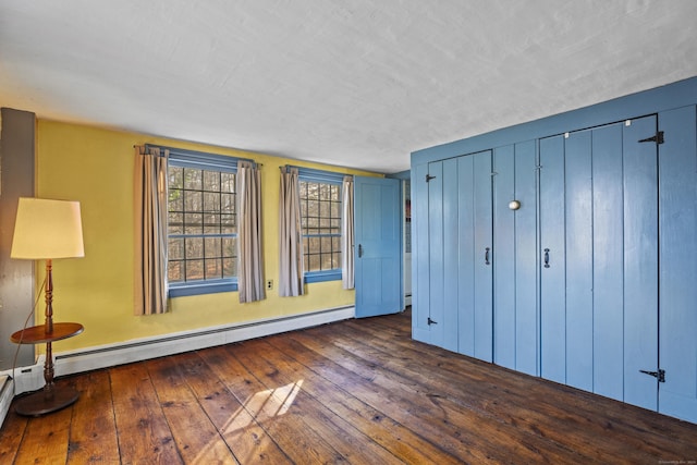 unfurnished bedroom with dark hardwood / wood-style flooring, a textured ceiling, and a baseboard radiator