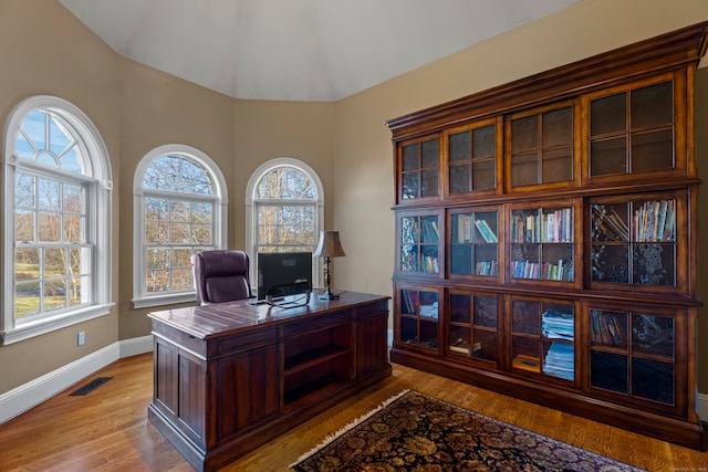 office featuring light wood-type flooring, vaulted ceiling, and plenty of natural light