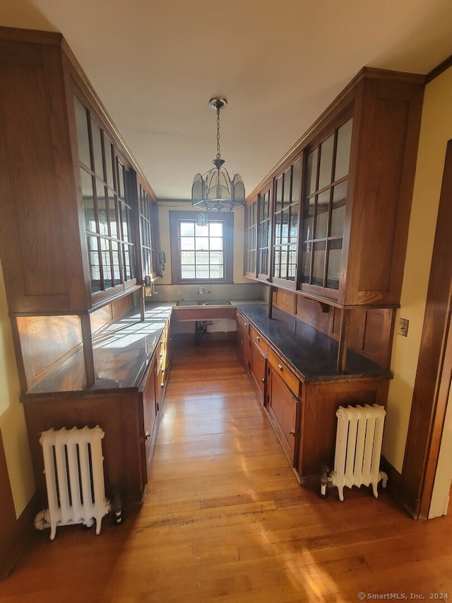 interior space featuring radiator heating unit, an inviting chandelier, light hardwood / wood-style flooring, and hanging light fixtures