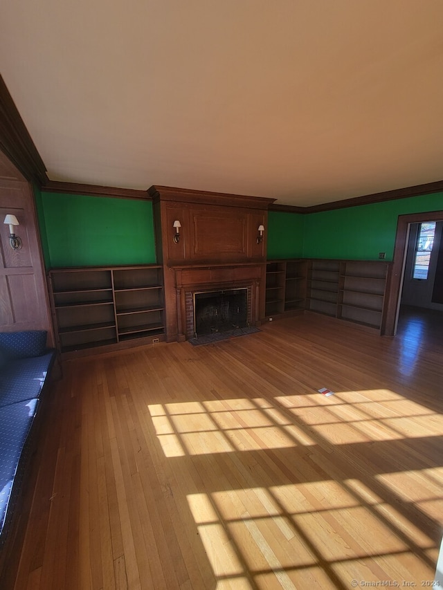 unfurnished living room with crown molding and light hardwood / wood-style flooring