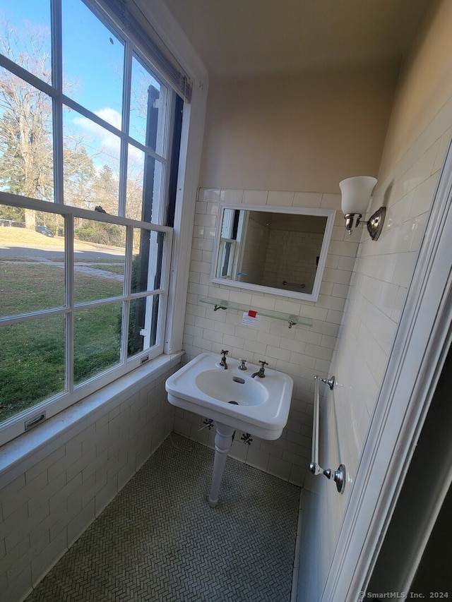 bathroom featuring tile patterned flooring, tile walls, and sink