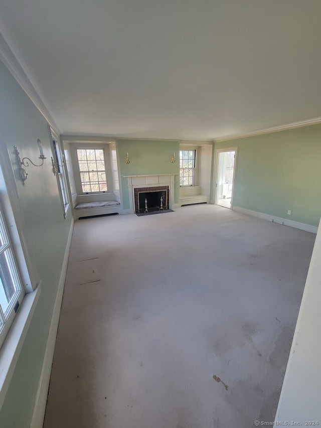 unfurnished living room with crown molding, a wealth of natural light, and concrete floors