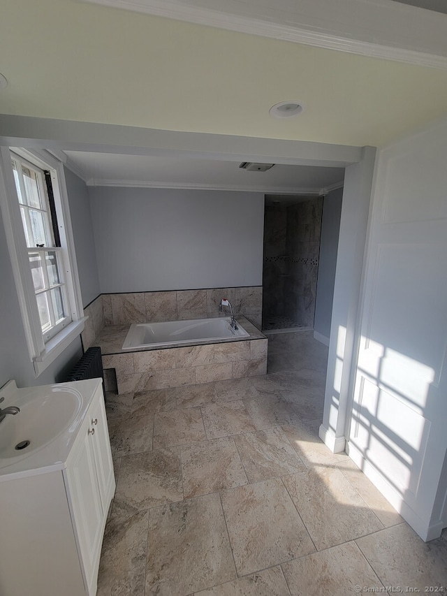 bathroom featuring vanity, ornamental molding, and tiled tub