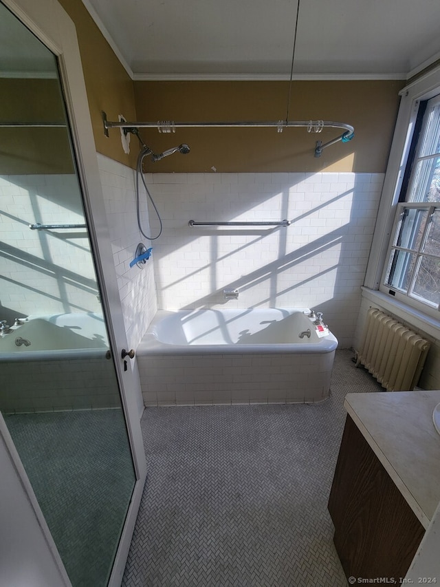 bathroom with radiator heating unit, vanity, tiled shower / bath combo, and crown molding