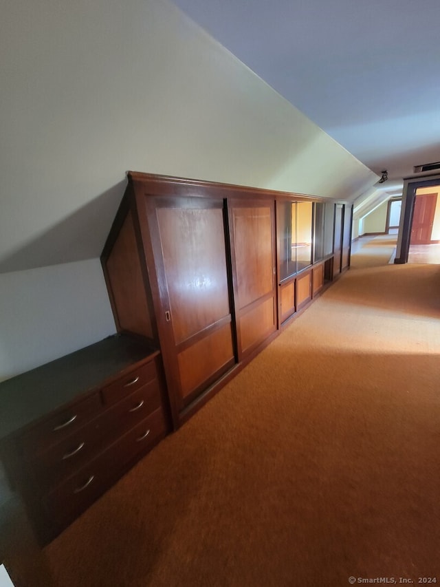 hall featuring carpet and vaulted ceiling