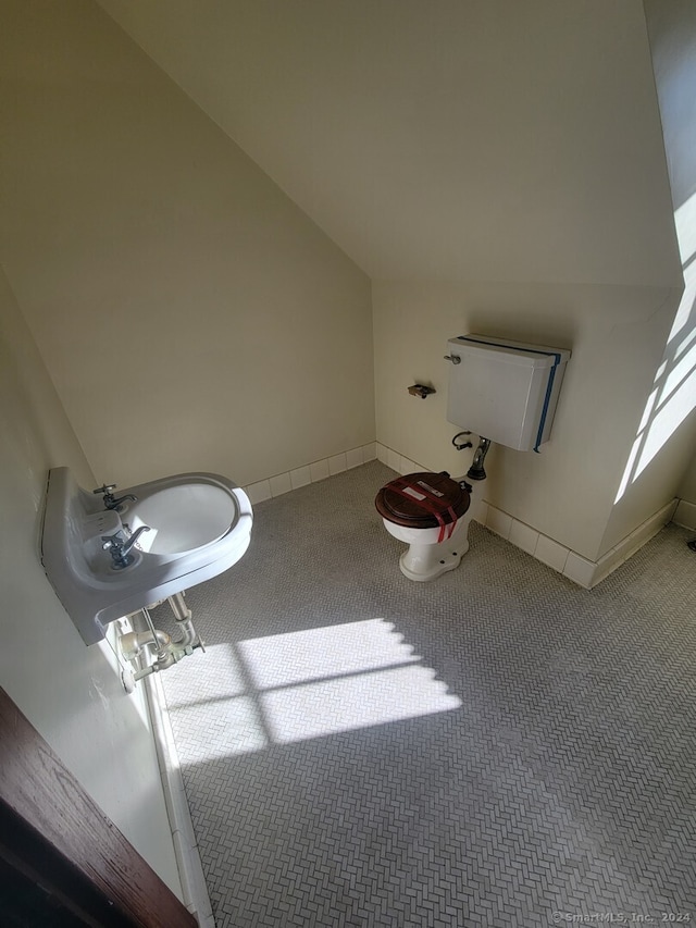 bathroom with toilet and lofted ceiling