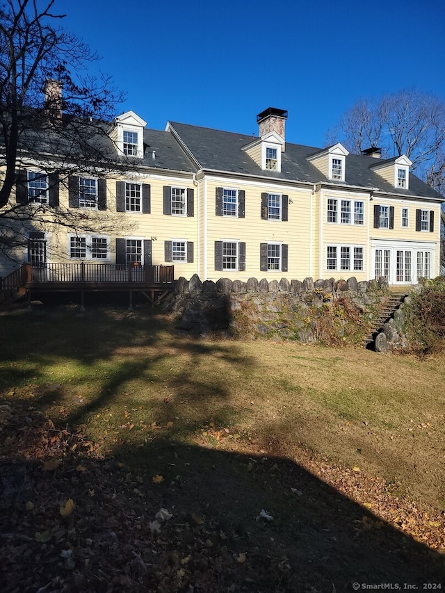 view of property exterior featuring a lawn and a wooden deck