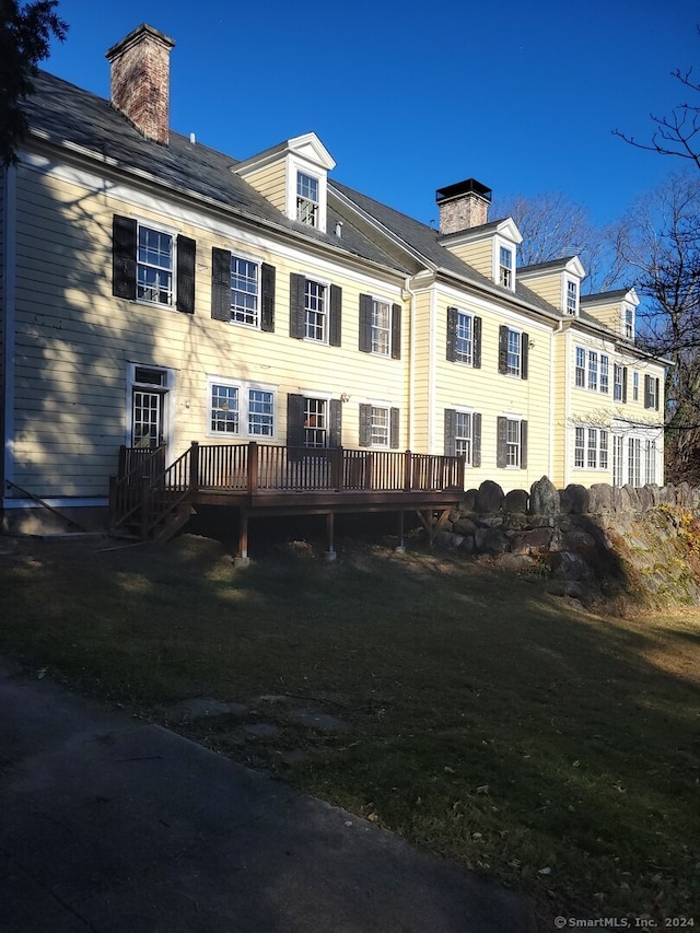 exterior space with a deck and a lawn