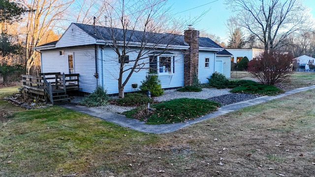 view of front facade featuring a wooden deck and a front lawn