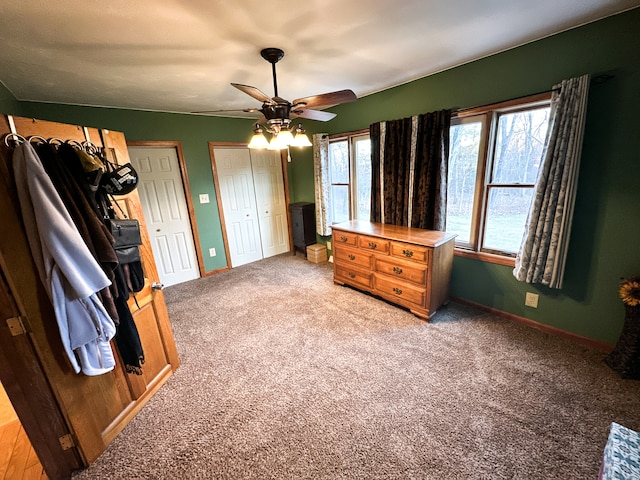 bedroom featuring carpet, ceiling fan, and multiple closets