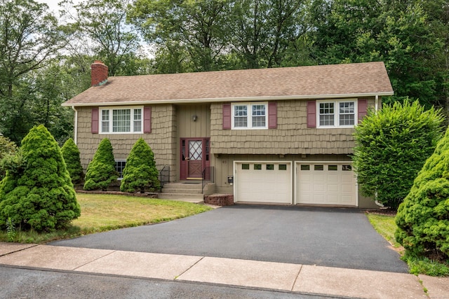 45 Wentworth Dr, East Hartford, CT 06118 - raised ranch with a chimney, driveway, an attached garage, a shingled roof, and a front yard