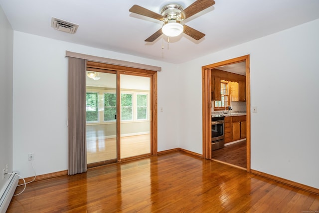 45 Wentworth Dr, East Hartford, CT 06118 - empty room with a baseboard heating unit, wood finished floors, and a ceiling fan
