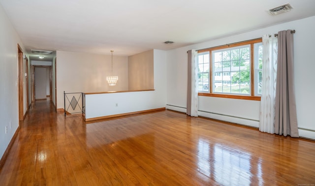 45 Wentworth Dr, East Hartford, CT 06118 - spare room featuring wood finished floors, a baseboard heating unit, a chandelier, and baseboard heating