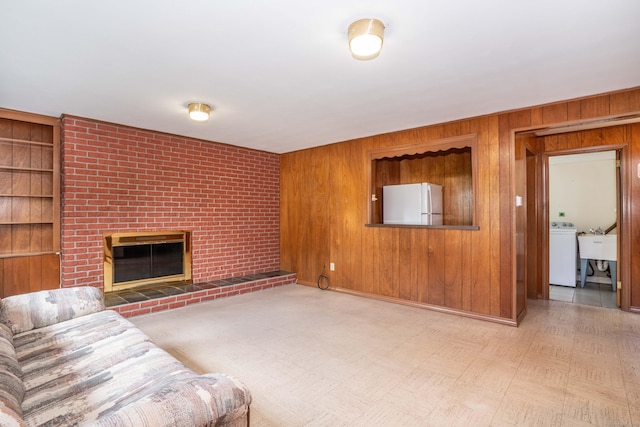 45 Wentworth Dr, East Hartford, CT 06118 - unfurnished living room featuring washer / clothes dryer, wooden walls, a brick fireplace, and built in shelves