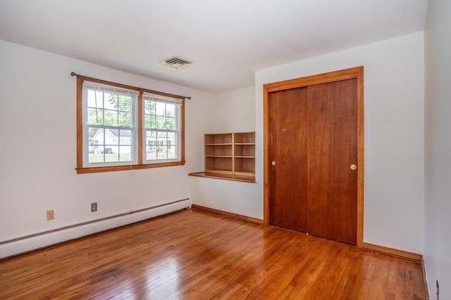 45 Wentworth Dr, East Hartford, CT 06118 - unfurnished bedroom with a baseboard heating unit, wood finished floors, and a closet