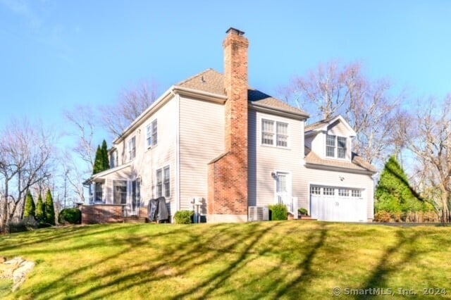 rear view of house featuring a yard and a garage