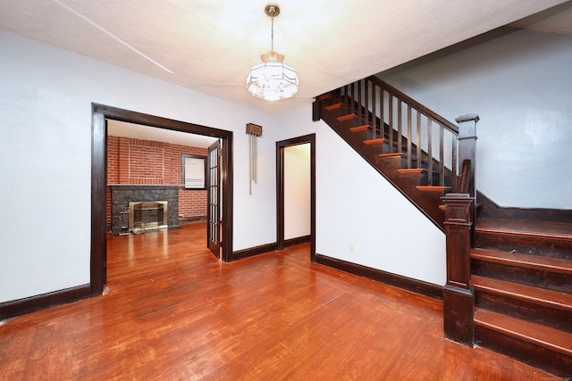 interior space featuring a fireplace, hardwood / wood-style floors, and a chandelier