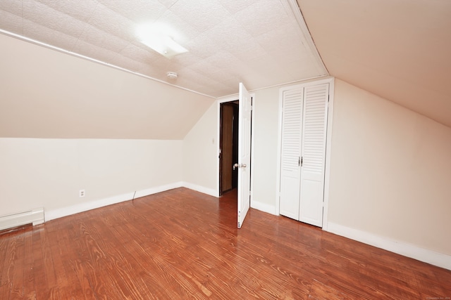 bonus room featuring a textured ceiling, vaulted ceiling, and hardwood / wood-style flooring