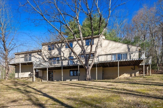 back of house with a lawn and a wooden deck