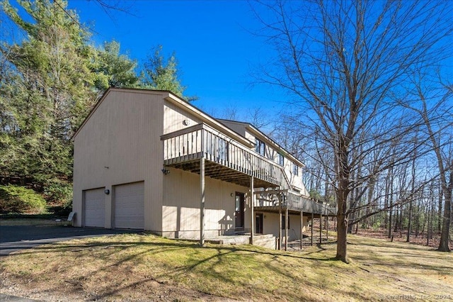 back of house with a lawn, a deck, and a garage