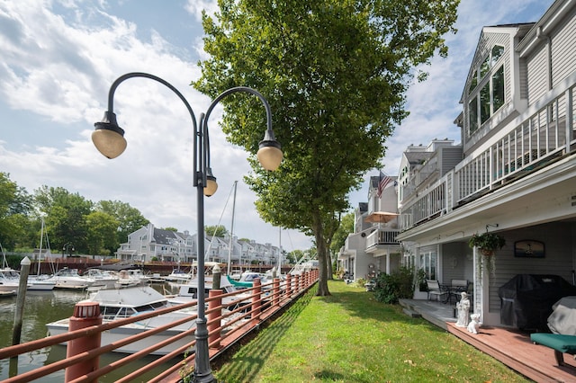 exterior space with a boat dock, a lawn, and a water view