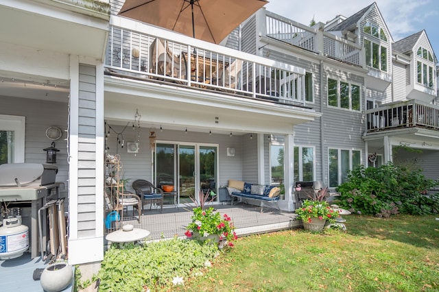 rear view of property with a balcony, a lawn, and an outdoor hangout area