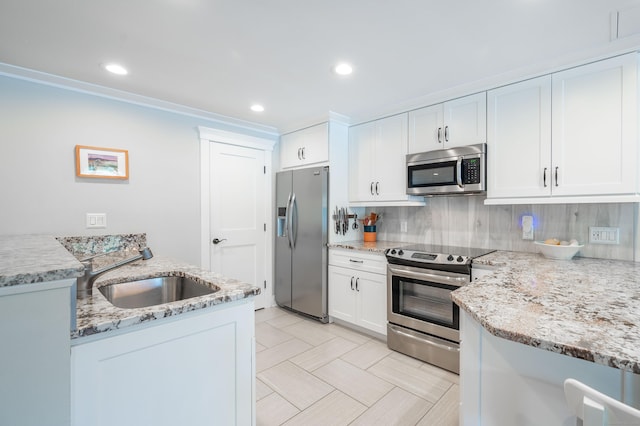 kitchen with sink, white cabinets, light stone countertops, and appliances with stainless steel finishes