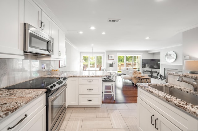 kitchen featuring sink, stainless steel appliances, white cabinetry, and crown molding