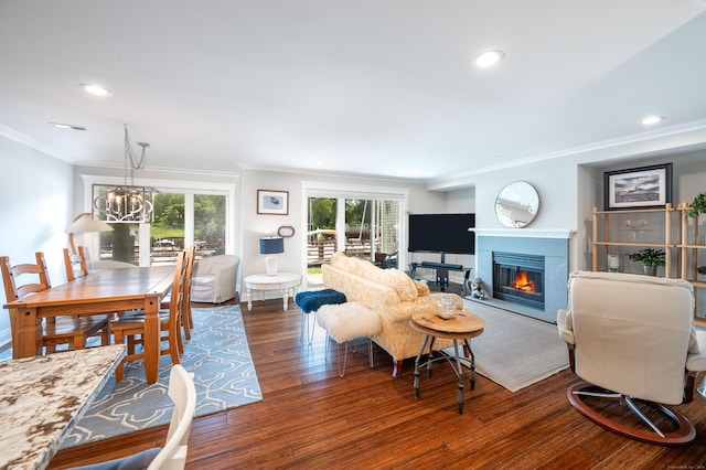 living room featuring crown molding, dark wood-type flooring, and a notable chandelier