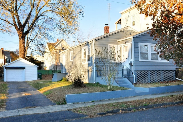 bungalow-style house with a garage and an outdoor structure