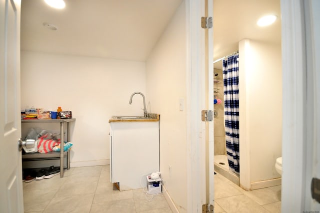 bathroom with toilet, tile patterned floors, walk in shower, and sink