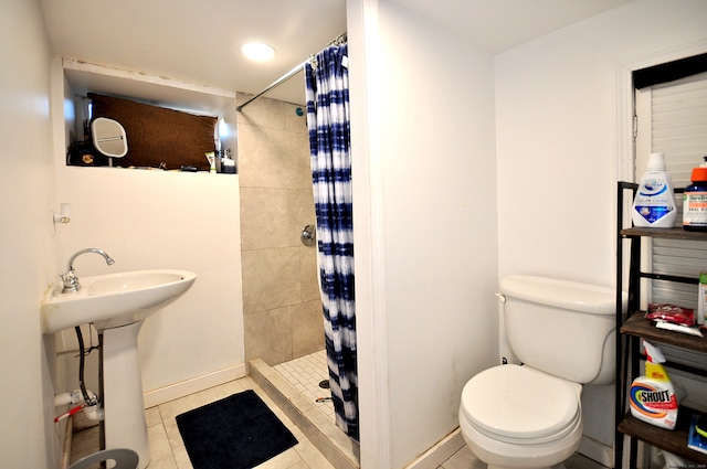 bathroom with a shower with shower curtain, tile patterned flooring, toilet, and sink